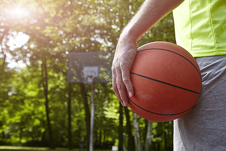 年轻男篮球运动员在篮球架前持球的裁剪细节背景图片