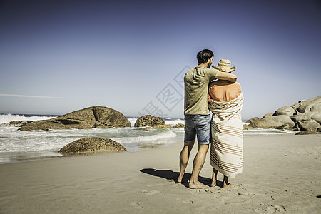 从海滩看一对包着毯子的夫妇图片