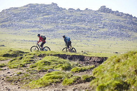 在山坡上骑自行车的运动员图片