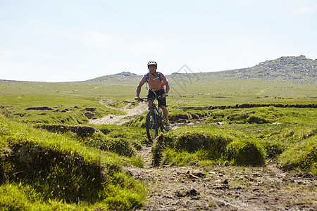 在岩石山坡上骑自行车的运动员图片