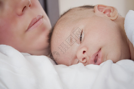 趴在母亲胸前睡的婴儿男孩图片