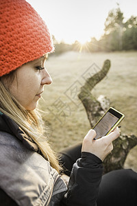 妇女在德国巴伐利亚奥格斯堡在树上休息的女性使用手机图片