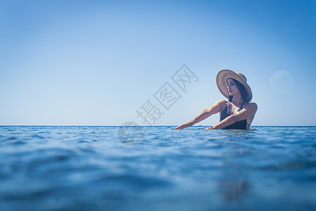 意大利撒丁岛比亚西米乌斯深蓝海穿防晒帽的年轻女子图片
