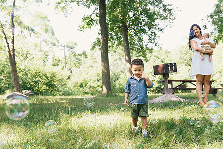 美国纽约布朗克斯PelhamBay公园与母亲和小弟一起玩泡的男幼儿美国纽约布朗克斯州PelhamBay公园图片