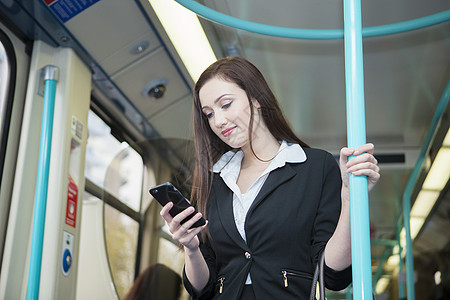 伦敦轻型铁路列车使用手机的女商人图片