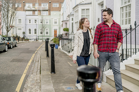 年轻夫妇在英国伦敦KingsRoad散步和牵手休闲服高清图片素材