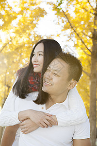 秋天公园里丈夫将妻子背在身上图片