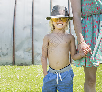 戴太阳眼镜和帽子的男孩握着母亲的手信心高清图片素材