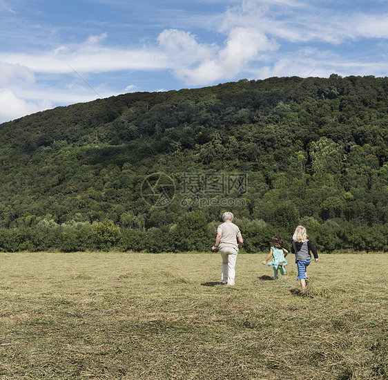 德国北莱茵威斯特伐利亚田野里奔跑的一家人图片