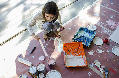 女孩在油漆罐中搅拌图片