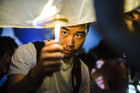 泰国清迈一名年轻男子为洛伊克拉通纸灯笼节点燃纸灯笼图片