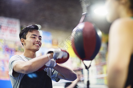 在健身房打速球的年轻男子拳击手图片