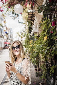 西班牙老城街上看摄影机微笑的女人图片