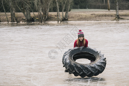 妇女在冷冻湖上翻轮胎图片