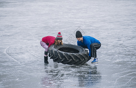 情侣在冰冻湖上翻轮胎图片