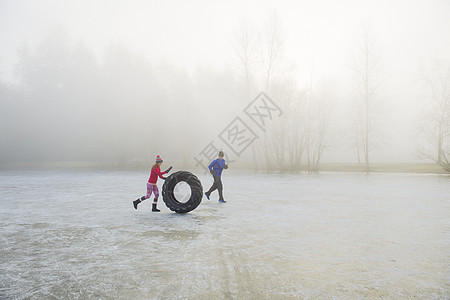 冷冻湖上的妇女滚动轮胎图片