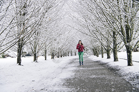 在雪中妇女沿路跑步图片