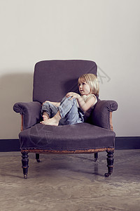 坐在沙发椅上的小女孩图片