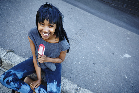 年轻女肖像户外吃冰棒高视率背景图片