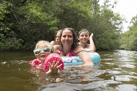 湖中带救生圈的母亲和儿童图片