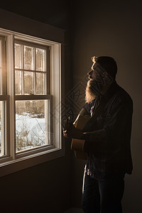 男人在窗边弹吉他图片