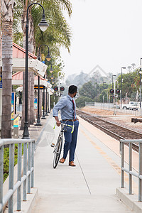 年轻商人骑自行车从火站站台回过头来图片