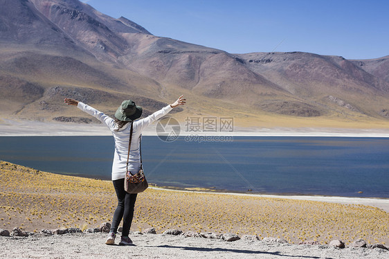 智利圣佩德罗德阿塔卡马米桑蒂湖边的妇女举起双臂图片