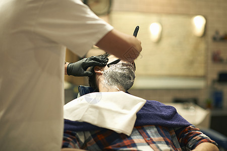 理发店修剪顾客胡子的理发师图片