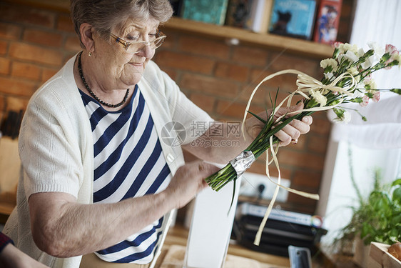 拿着一束花的老年妇女图片