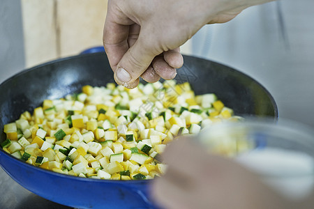厨师在煎锅里煮蔬菜特制图片