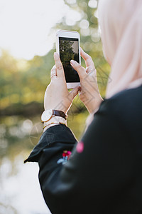 年轻女子用智能手机照相高清图片