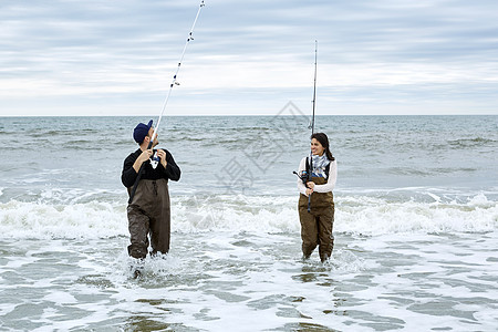 在大海海滩边钓鱼的情侣图片
