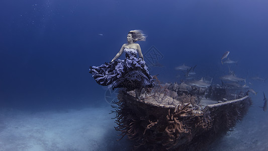 身穿紫色衣服的美女站在水下的沉船上图片