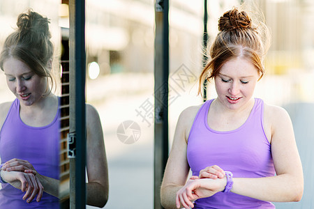 年轻女选手在城市人行道上观看智能察图片