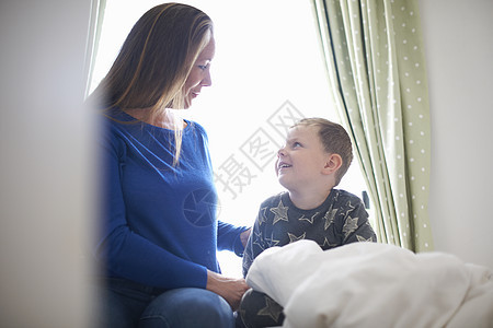 男孩坐在床上和妈聊天图片