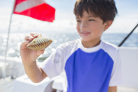 男孩检查船上的扇贝底潜水旗墨西哥湾佛罗里达州美国图片