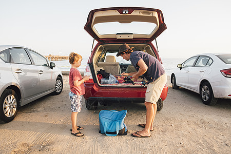美国加利福尼亚州戈莱塔北美的父亲和儿子从汽车后备箱里拿鱼杆图片