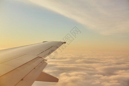 云层上空飞行的机翼图片