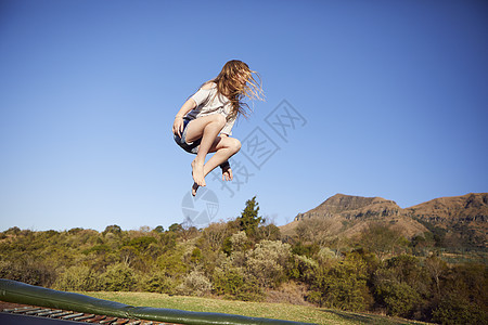 少女在蹦床上跳跃图片