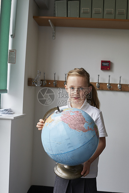 女孩在小学课堂上把地球仪拿进小学教室里图片