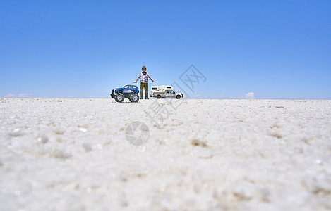 男孩和玩具卡车在盐滩上玻利维亚南美洲图片