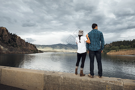站在湖边的墙上观景的夫妇美国科罗拉多州图片