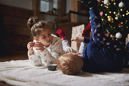 女孩和男孩在圣诞树旁边玩耍图片