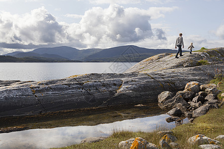 人类和儿子在挪威的岩层上行走图片