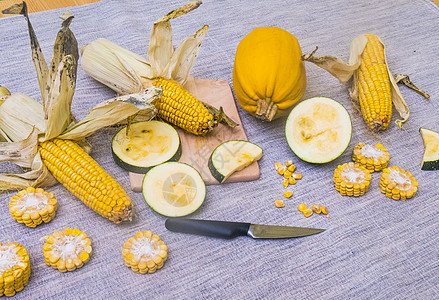 整个的南瓜玉米和砧板上切开的南瓜玉米图片