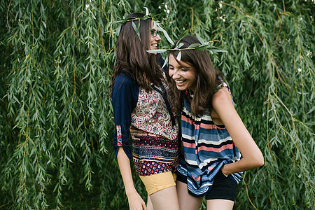 两个姐妹一个带着柳枝一个带着墨镜在微笑图片