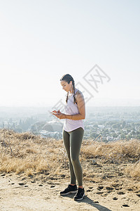 在美国洛杉矶山顶使用手机的妇女图片