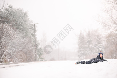 冬天男孩躺在雪上图片