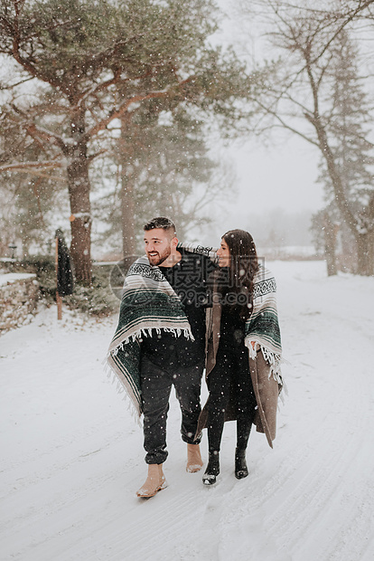在加拿大乔治敦的雪地上裹着毯子行走的情侣图片