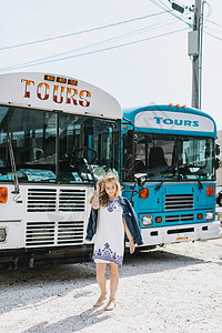 旅游巴士前的年轻女子图片